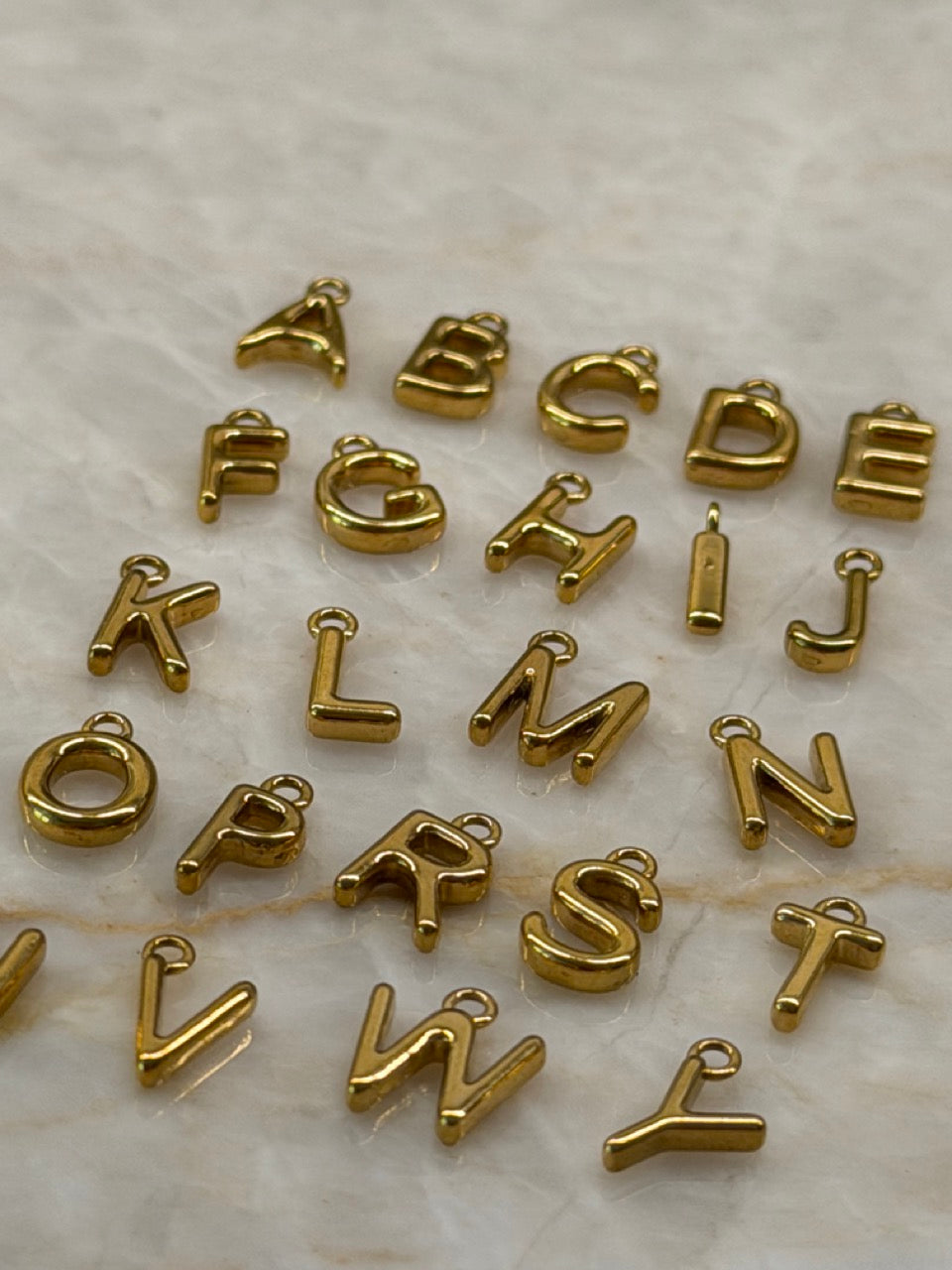 Mini Buchstaben Anhänger Gold in der Nahaufnahme