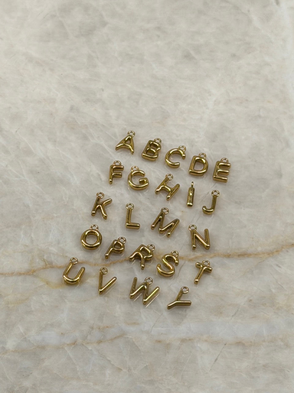 Detailaufnahme der Mini Buchstaben Anhänger in Gold